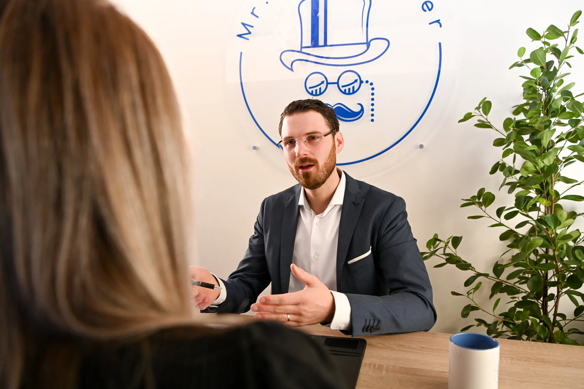 Kennismakingsgesprek aan tafel bij Mr. Bookkeeper, met het logo aan de muur